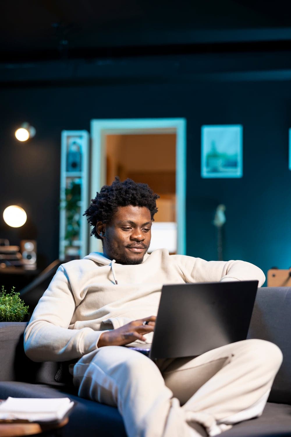 A freelancer working on a laptop from his sofa