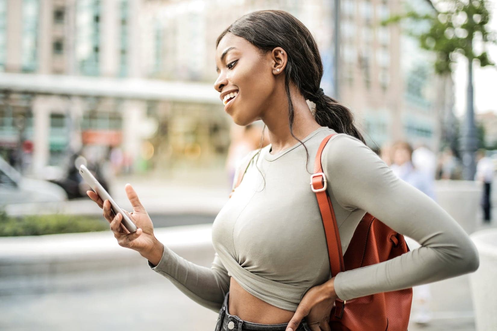 A traveller checking her phone on a city street